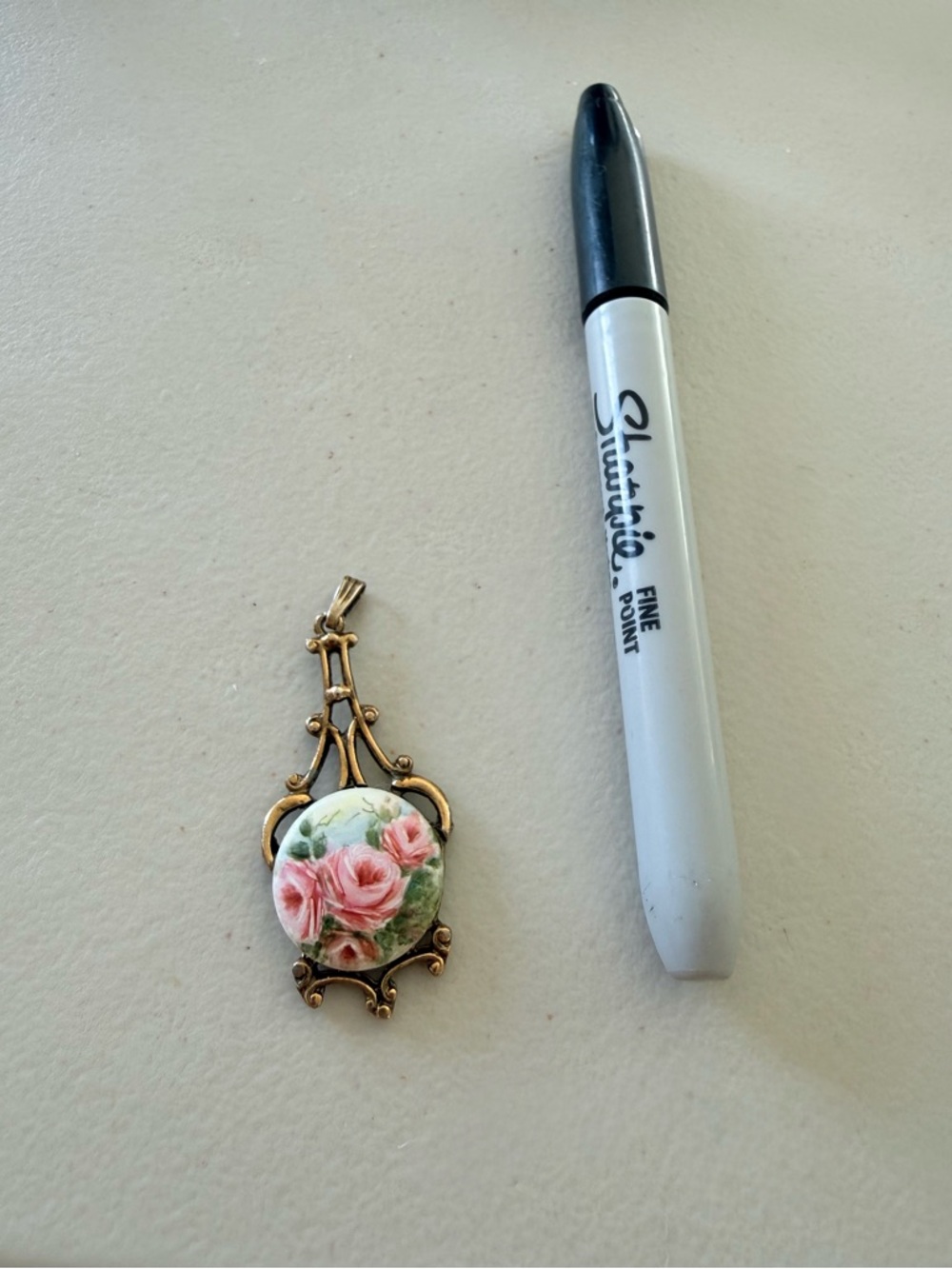 Vintage hand painted porcelain pendant.  Features Roses ornate gold-tone frame